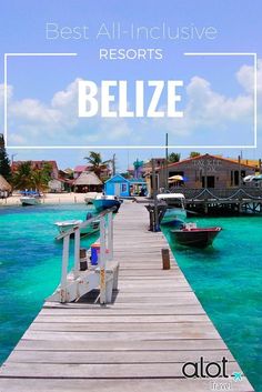 a dock leading into the water with boats docked in front of houses on stilts