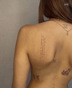 the back of a woman's body with tattoos on it