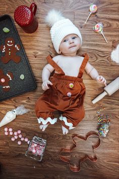 a baby is laying on the floor with gingerbread cookies and other items around it