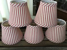 four red and white striped lampshades sitting on top of a table