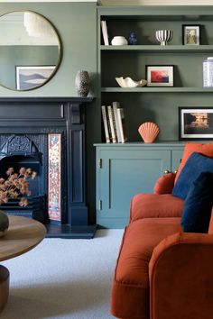 a living room filled with furniture and a fire place in front of a book shelf