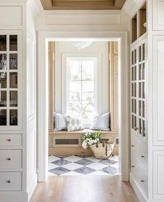 an open door leading to a room with white walls and wood flooring on the side