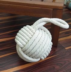 a white rope ball sitting on top of a wooden floor