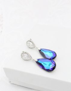 "If you are looking for purple earrings to make a statement, these Luxury Heliotrope color Swarovski Earrings are your best option! They are also a big favorite for Peacock themed Weddings and the teardrop crystals feature multiple colors, predominantly Purple and Turquoise. A must have for your Purple outfit! These luxury Teardrop Earrings are made of sparkly Purple Genuine Swarovski crystals that hang from nickel free Solid Sterling Silver post earrings (the whole earring, not just the post!) Elegant Peacock Earrings For Wedding, Elegant Peacock Colored Earrings For Wedding, Peacock Colored Earrings For Wedding, Elegant Peacock-colored Earrings As A Gift, Elegant Peacock Colored Earrings For Gift, Elegant Peacock-colored Earrings For Gift, Peacock Jewelry, Turquoise Earring, Purple Outfit