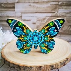 a colorful butterfly sitting on top of a piece of wood