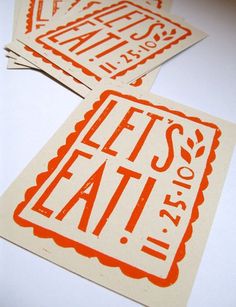 three orange and white stickers that say let's eat