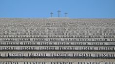 three crosses on top of a building with words written in front of it and the sky behind them