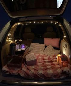 the back of a van with lights and blankets in it