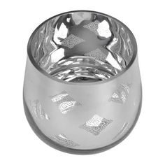 an empty glass cup sitting on top of a white surface with silver foil around it