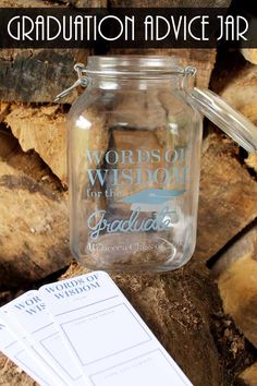 a mason jar sitting on top of a pile of wood with the words graduation advice jar next to it