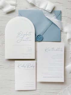 the wedding stationery is laid out on top of each other, including an envelope with a wax seal