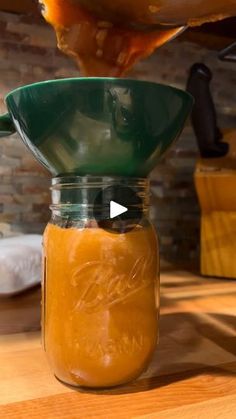 a jar filled with liquid sitting on top of a wooden table