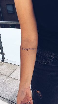 a woman with a small tattoo on her arm that says, i love you in cursive writing