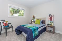 a bed room with a neatly made bed next to a small table and two chairs