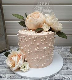 there is a cake with flowers on the top and pearls on the bottom that says happy birthday