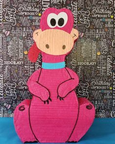 a pink stuffed animal sitting on top of a blue table next to a black and white wall