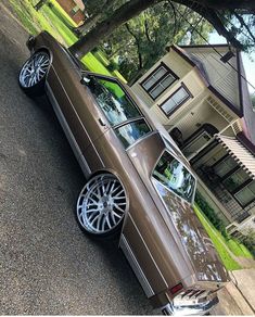 a brown car parked in front of a house