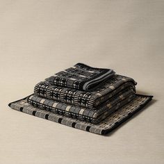 stack of black and white cloths on top of each other in front of a beige background