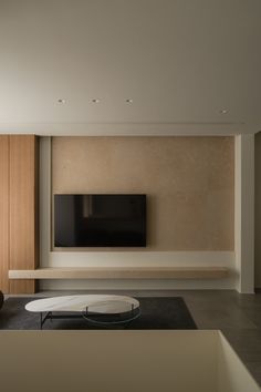 a living room with a large flat screen tv mounted on the wall above a coffee table