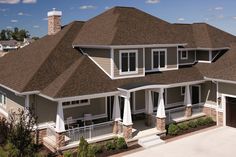 an aerial view of a house with brown shingles and white trim