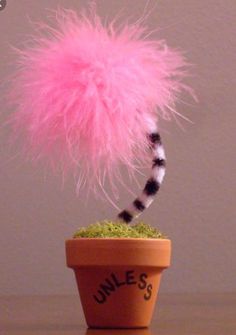 a pink fuzzy ball on top of a potted plant with the word june's written below it