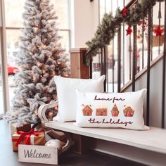 two pillows on a bench next to a christmas tree