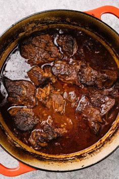 a pot filled with beef and sauce on top of a table