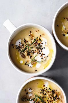 three white cups filled with soup on top of a marble counter topped with sprinkles