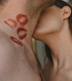 a man and woman kissing each other with red lipstick on their faces