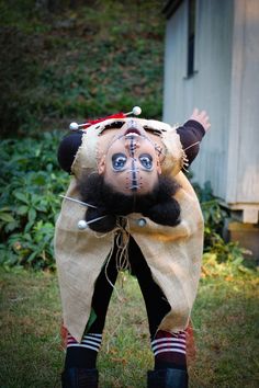 a scarecrow doll standing in the grass with his head on top of another doll