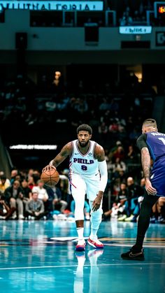 two men playing basketball in front of an audience