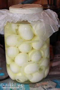 a jar filled with white eggs sitting on top of a table next to a newspaper