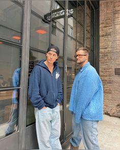 two men standing in front of a building