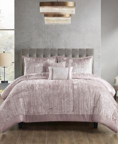 a bed with a pink comforter and pillows