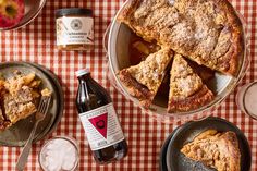 a table topped with pies and drinks on top of a checkered table cloth