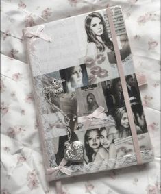 a book with pictures on it sitting on top of a white bed cover covered in pink flowers