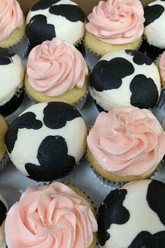 cupcakes with pink frosting and black polka dots on them in a box