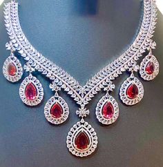 Experience the timeless elegance of our CZ American Diamond Necklace, featuring vibrant ruby pink colorstones. Perfectly complementing sarees, gowns or lehengas, this necklace adds a touch of glamour to any outfit. Complete the look with the included big earrings. Makes for a thoughtful and stylish gift. This jewellery set includes a necklace and matching earrings. Jewellery Care- Keep the jewellery dry, avoid contact with perfumes and water. Luxury Ruby Bridal Necklace, Elegant Red Jewelry Sets For Diwali, Formal Ruby Jewelry For Diwali, Elegant Ruby Bridal Necklace For Diwali, Elegant Ruby Bridal Necklace For Festive Occasion, Elegant Ruby Bridal Necklace For Festive Season, Elegant Chandbali Ruby Jewelry Sets, Exquisite Red Bridal Necklace For Celebrations, Elegant Ruby Jewelry Sets For Reception