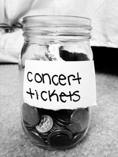 a jar filled with coins and a sign that says concert tickets