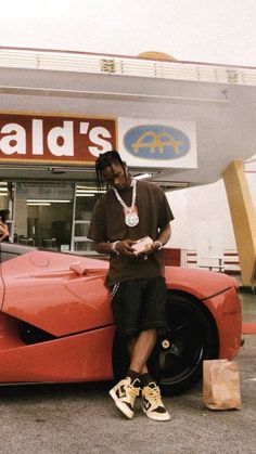 a man standing next to a red sports car