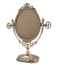 an ornately decorated gold mirror on a stand