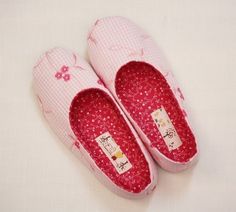 two pairs of pink and white slippers with hello kitty on the front, one pair is