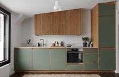 a kitchen with green cabinetry and wooden accents, along with an area rug on the floor