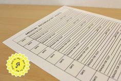 a close up of a piece of paper on top of a wooden table with a yellow seal