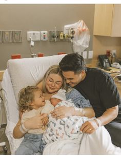 a man and woman holding a baby in a hospital bed