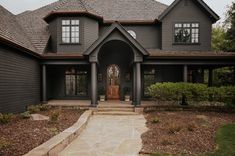 a large gray house with stone steps leading to the front door