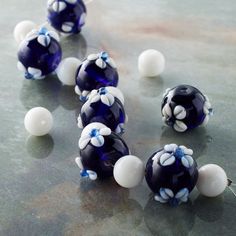 several blue and white glass beads on a counter top with one bead in the middle