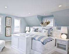 a bedroom with blue walls and white furniture