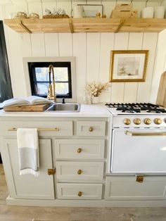 a white stove top oven sitting inside of a kitchen next to a wooden countertop