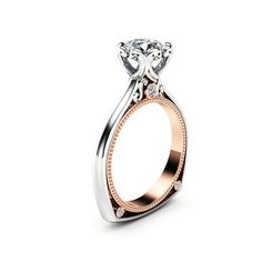 a diamond engagement ring with two tone gold and white diamonds on the band, set in 18k rose gold